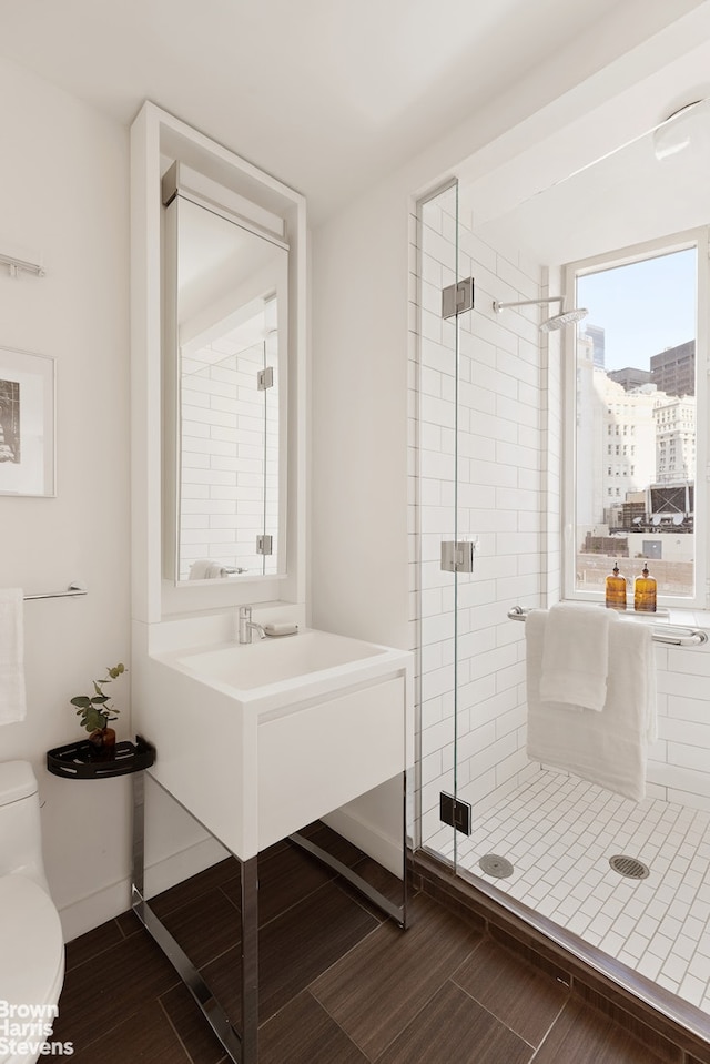 15 William St Unit 33I, New York City, NY 10004 - bathroom featuring a shower stall, toilet, wood finished floors, and vanity