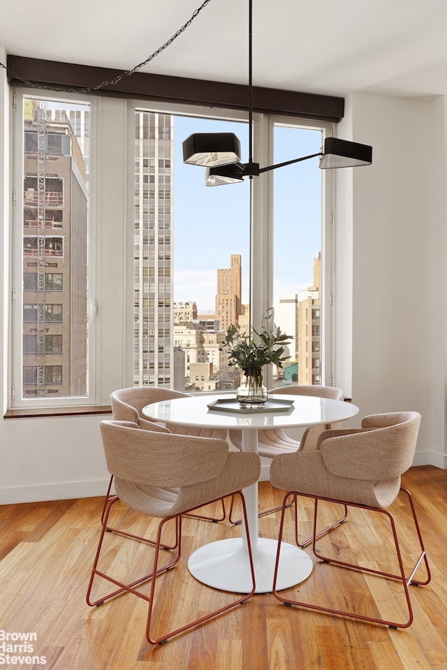 15 William St Unit 33I, New York City, NY 10004 - dining room with a view of city, a wall of windows, wood finished floors, and baseboards