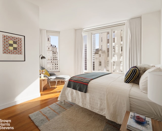15 William St Unit 33I, New York City, NY 10004 - bedroom with wood finished floors, baseboards, and access to outside