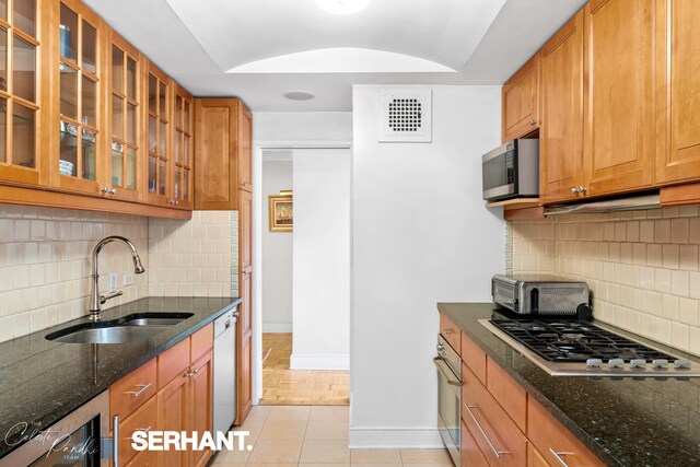 132 E 35th St Unit 16Gh, New York City, NY 10016 - kitchen featuring a sink, stainless steel appliances, baseboards, backsplash, and dark stone countertops