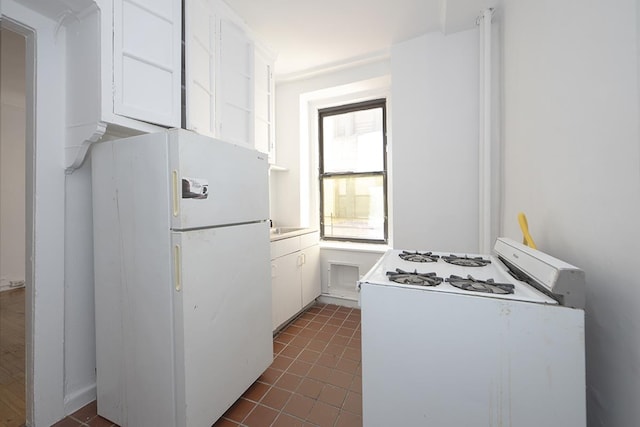 409 Edgecombe Ave Unit 1-D, New York City, NY 10032 - kitchen featuring white appliances, white cabinets, and dark tile patterned floors