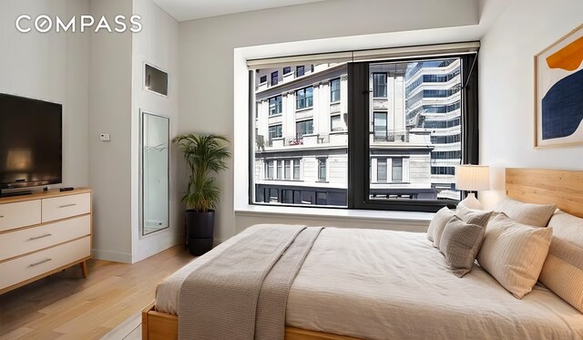 75 Wall St Unit 24M, New York City, NY 10005 - bedroom featuring light wood finished floors and baseboards
