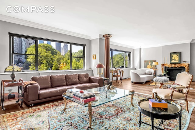 785 5th Ave Unit 3C, New York City, NY 10022 - living area featuring crown molding, wood finished floors, decorative columns, and a fireplace