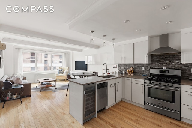201 E 25th St Unit 7F, New York City, NY 10010 - kitchen with appliances with stainless steel finishes, wall chimney exhaust hood, a sink, open floor plan, and ornamental molding