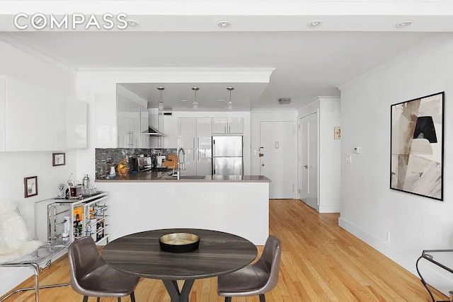 201 E 25th St Unit 7F, New York City, NY 10010 - dining area featuring ornamental molding, light wood-style flooring, and baseboards