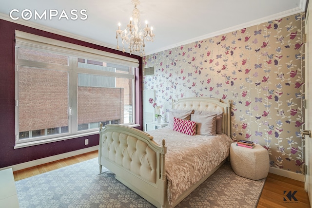 bedroom with ornamental molding, wood finished floors, a chandelier, and wallpapered walls