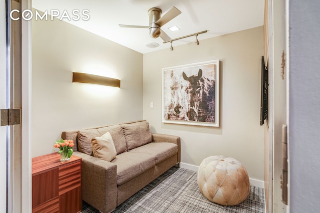 sitting room with a ceiling fan and baseboards