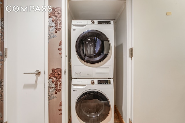 washroom featuring stacked washer and clothes dryer and laundry area