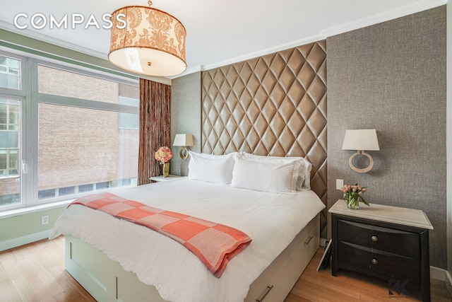 bedroom featuring crown molding, baseboards, and wood finished floors