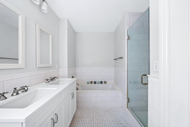 bathroom with a stall shower, a garden tub, and double vanity