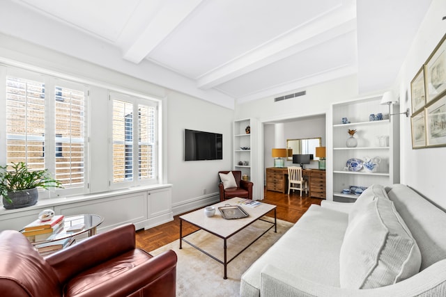 living area featuring beam ceiling and built in shelves