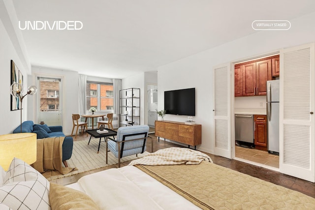 bedroom featuring baseboards, ensuite bathroom, and freestanding refrigerator