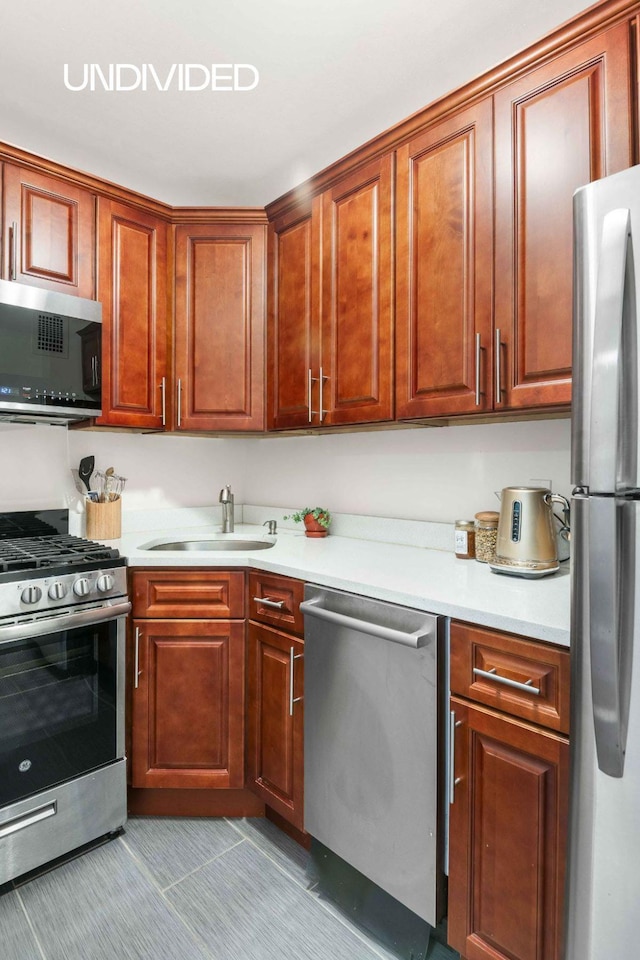 kitchen with a sink, appliances with stainless steel finishes, and light countertops