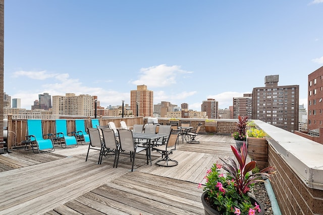 wooden deck featuring a view of city and outdoor dining space