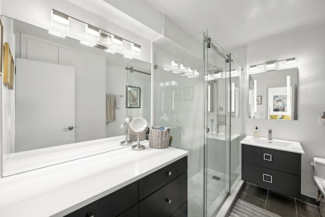 bathroom with tile patterned floors, a shower stall, toilet, and vanity