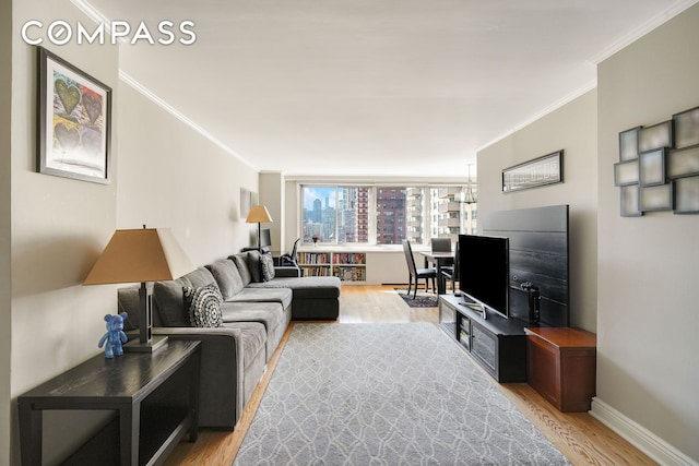 living area featuring crown molding, light wood-style floors, and baseboards