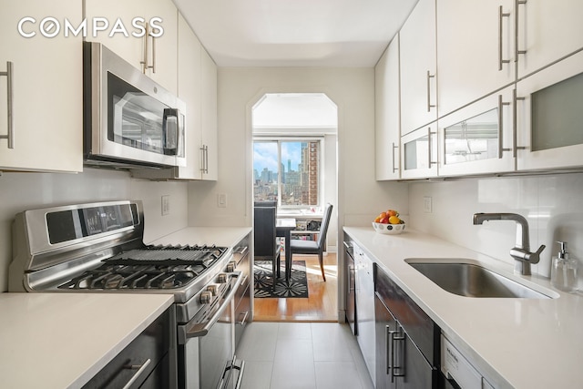 401 E 86th St Unit 15C, New York City, NY 10028 - kitchen featuring stainless steel appliances, light countertops, and white cabinets