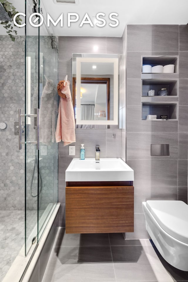 90 Furman St Unit N609, New York City, NY 11201 - full bathroom featuring tile walls, vanity, a stall shower, and tile patterned floors