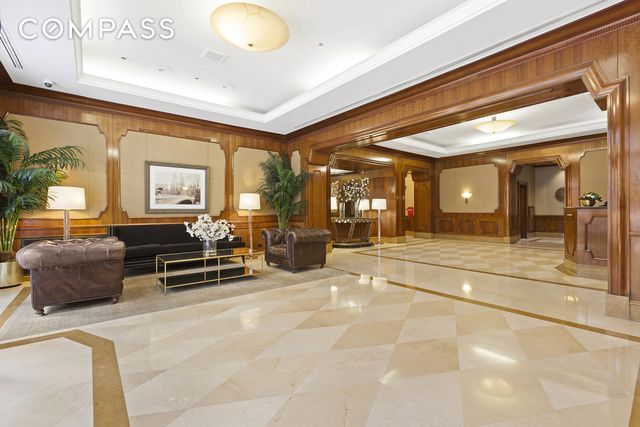 building lobby with crown molding, wood walls, and a security system