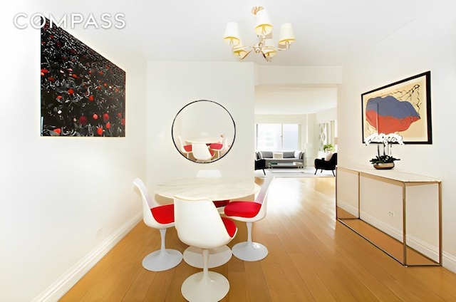 249 E 48th St Unit 16E, New York City, NY 10017 - dining room featuring wood finished floors and a chandelier