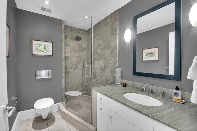 bathroom with visible vents, a shower stall, vanity, baseboards, and toilet