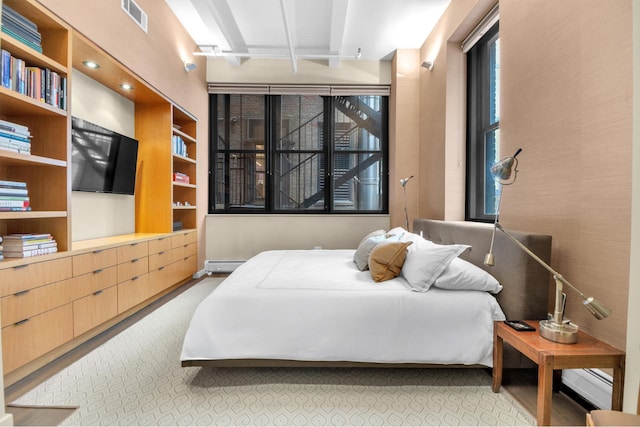 bedroom featuring baseboard heating, carpet, and visible vents