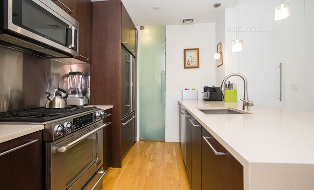 kitchen featuring visible vents, appliances with stainless steel finishes, modern cabinets, a sink, and light countertops