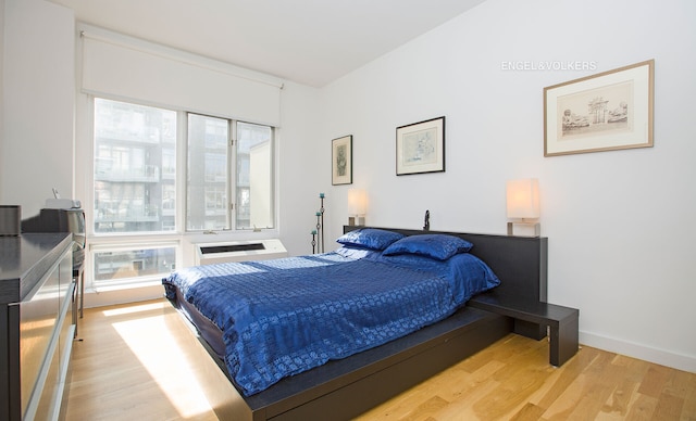 bedroom with baseboards and wood finished floors