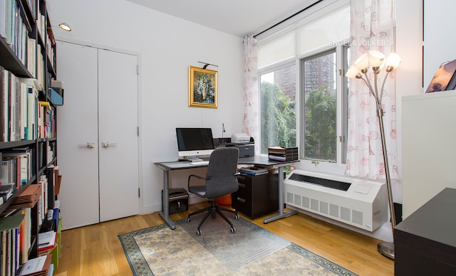 office space with light wood-style floors and radiator heating unit
