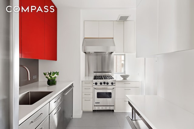 863 Park Ave Unit 8W, New York City, NY 10075 - kitchen with light countertops, a sink, stainless steel appliances, wall chimney range hood, and visible vents