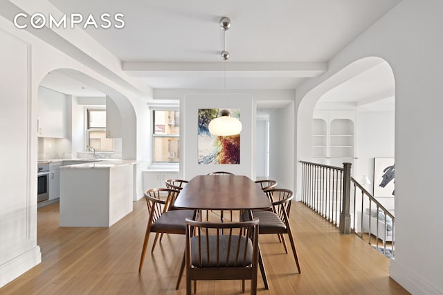 434 E 52nd St Unit 10E, New York City, NY 10022 - dining area with arched walkways and light wood-style flooring