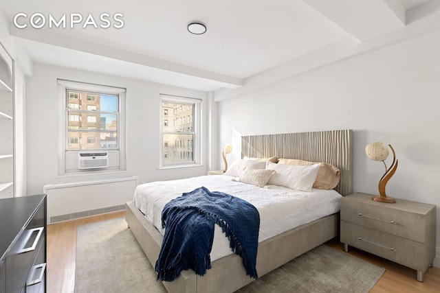 434 E 52nd St Unit 10E, New York City, NY 10022 - bedroom with light wood-type flooring, radiator, and cooling unit