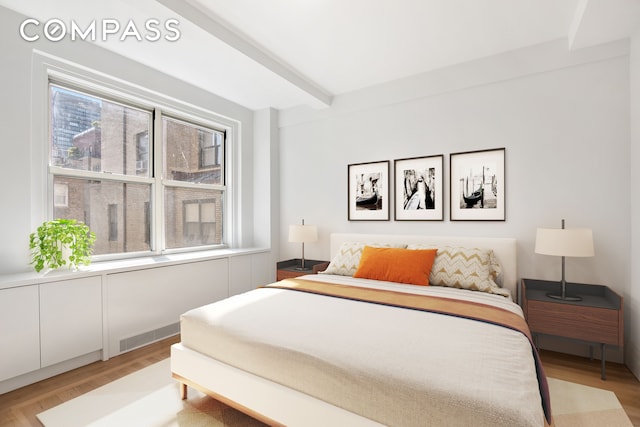 434 E 52nd St Unit 10E, New York City, NY 10022 - bedroom with light wood-style flooring and beam ceiling