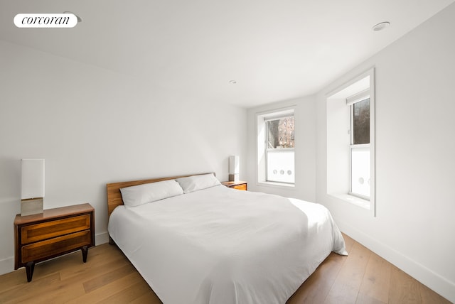 bedroom with baseboards and light wood finished floors
