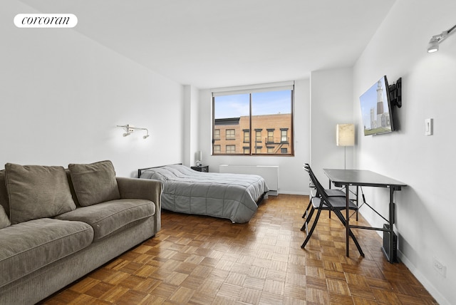 bedroom with radiator heating unit, baseboards, and visible vents