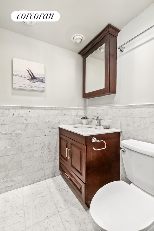 150 Joralemon St Unit 11D, New York City, NY 11201 - half bathroom with vanity, wainscoting, tile walls, and marble finish flooring