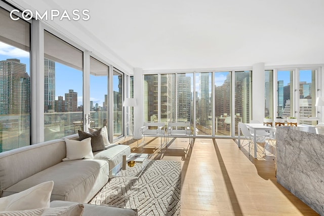 301 E 61st St Unit 16A, New York City, NY 10065 - sunroom featuring wood finished floors, a skyline view, plenty of natural light, and floor to ceiling windows