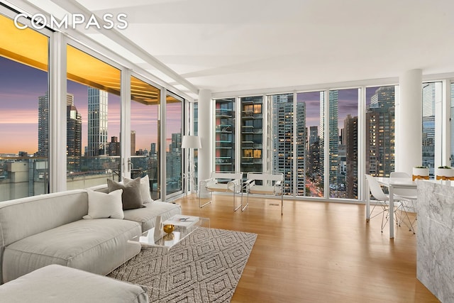 301 E 61st St Unit 16A, New York City, NY 10065 - living area with expansive windows, wood finished floors, and a view of skyline