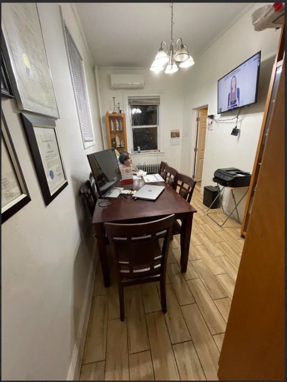 dining room featuring radiator, wood finish floors, a wall mounted air conditioner, and a notable chandelier