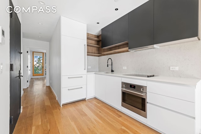 42 Rochester Ave Unit 3, New York City, NY 11233 - kitchen featuring stainless steel oven, modern cabinets, open shelves, black electric stovetop, and light countertops
