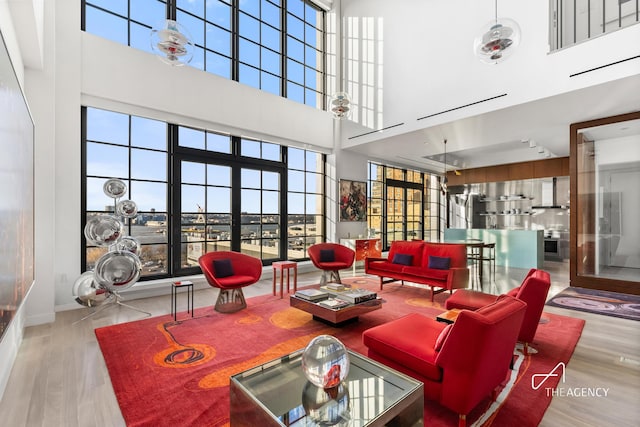 200 11th Ave Unit 7S, New York City, NY 10011 - living room with a towering ceiling, plenty of natural light, wood finished floors, and baseboards