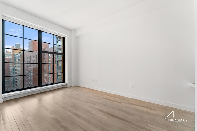 200 11th Ave Unit 7S, New York City, NY 10011 - empty room featuring wood finished floors, baseboards, and a view of city