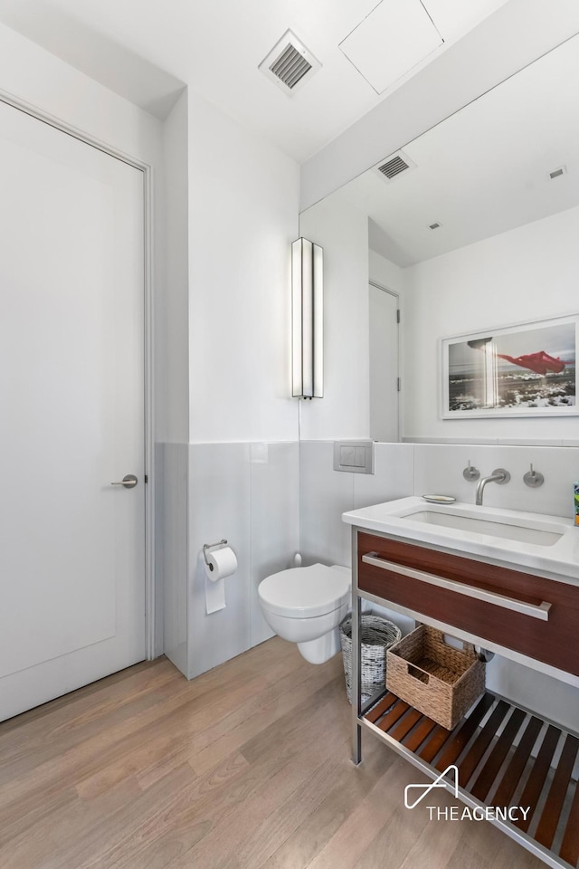 200 11th Ave Unit 7S, New York City, NY 10011 - bathroom featuring toilet, wood finished floors, wainscoting, and vanity