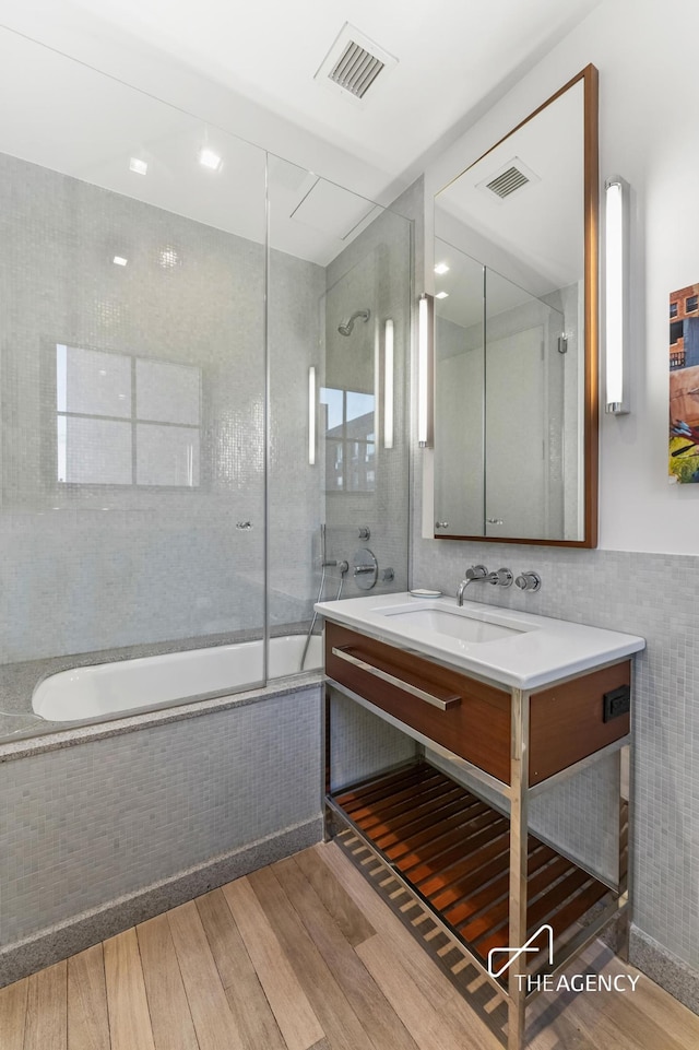 200 11th Ave Unit 7S, New York City, NY 10011 - full bathroom with wood finished floors, vanity, tiled shower / bath combo, and tile walls