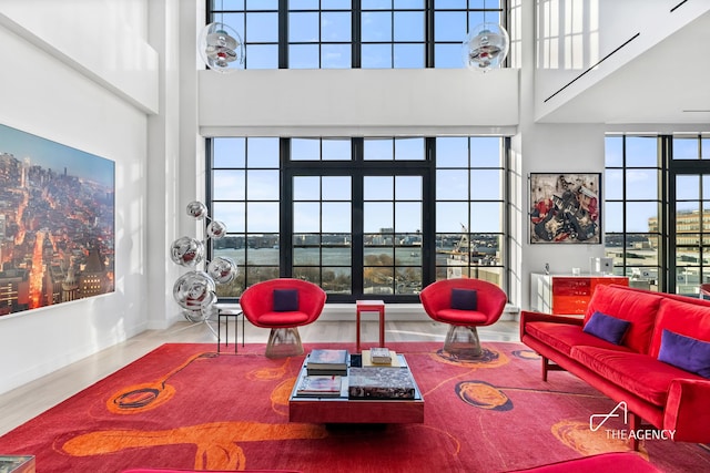 200 11th Ave Unit 7S, New York City, NY 10011 - living area featuring a towering ceiling, wood finished floors, and baseboards