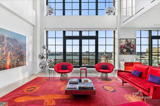 200 11th Ave Unit 7S, New York City, NY 10011 - living area featuring a towering ceiling, wood finished floors, and baseboards