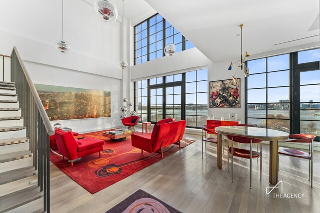 200 11th Ave Unit 7S, New York City, NY 10011 - living room with a towering ceiling, stairs, and wood finished floors