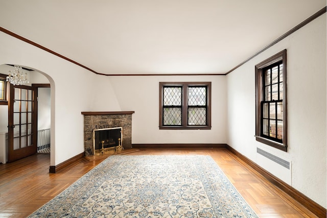 unfurnished living room featuring a wealth of natural light, visible vents, baseboards, and ornamental molding