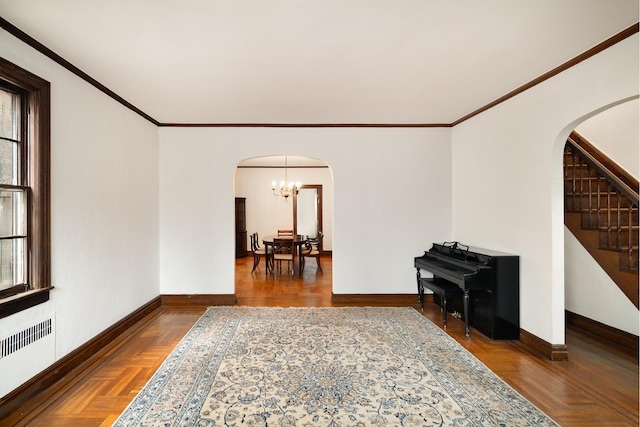 living area featuring arched walkways, radiator heating unit, and baseboards