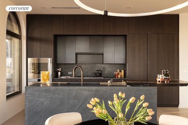 130 William St Unit 64B, New York City, NY 10038 - kitchen with modern cabinets, decorative backsplash, dark countertops, dark brown cabinets, and oven